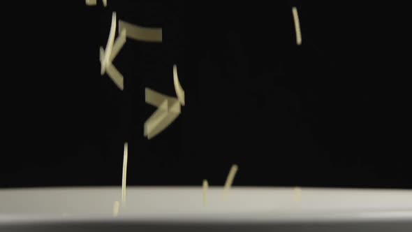 Small Noodles Fall On A White Dish And Bounce