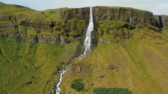 Aerial Drone Footage of Bjarnarfoss Waterfall with Its Green Cliffs in Western Iceland