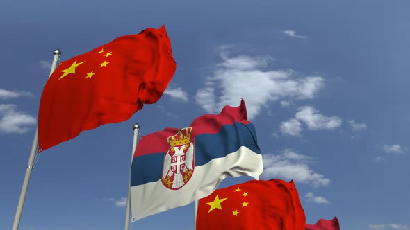 Waving Flags of Serbia and China on Sky Background