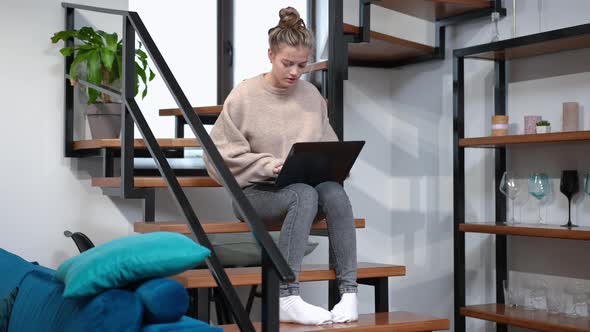 Wide Shot Portrait of Concentrated Teenage Girl Messaging Online Typing on Laptop Keyboard Sitting