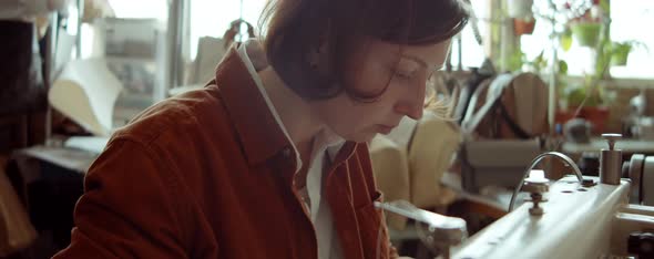 Female Shoemaker Using Sewing Machine at Work