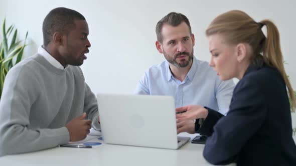 Business People Arguing While Using Laptop in Office