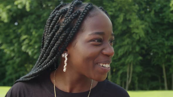 Portrait of Cute Positive African American Teenage Girl Talking Outdoors