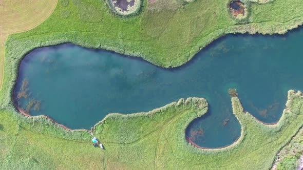 Aerial view of peaceful ponds on a green meadow