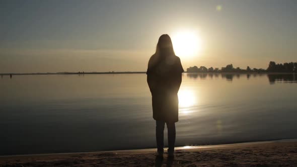 Woman Standing Near the Sea Shore at Dawn
