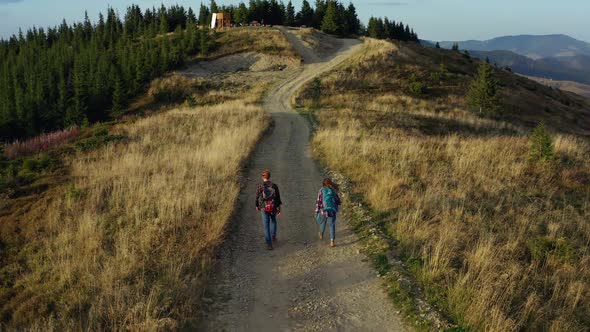 Aerial Couple Trekking Road on Mountains Enjoying Time Warm Spring Morning