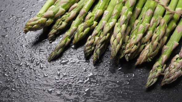 Raw Green Asparagus on Black Slate Background