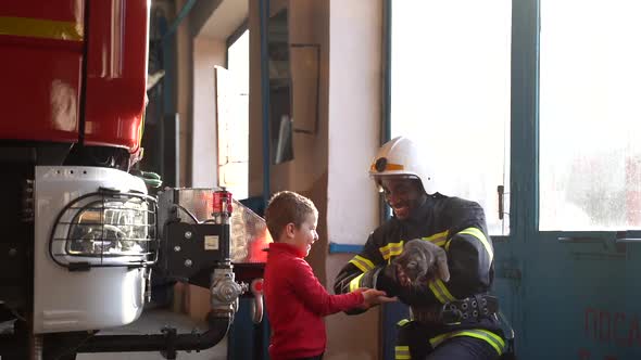 Fire Guard Giving a Car to a Little Girl at the Station