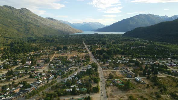 Dolly in flying over Lago Puelo valley with a beautiful woodland, lake and Andean mountains in backg