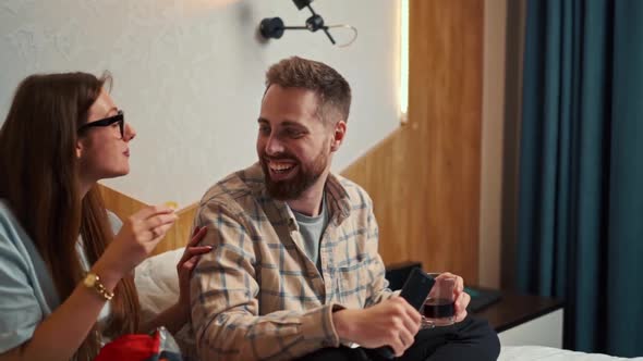 young couple watching football in hotel room