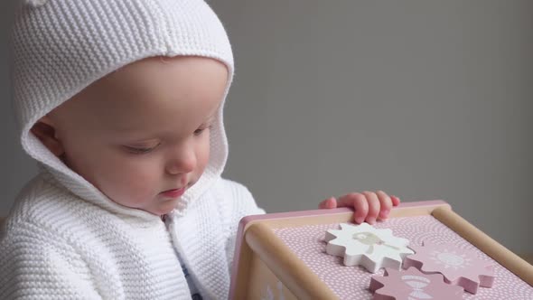 Cute Baby In Knitted Sweater Playing With Wooden Toy