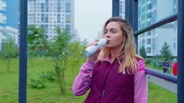 Fit Girl Drinks Yogurt From Bottle on Street Gym