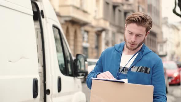 Delivery Driver Checking His List of Parcels