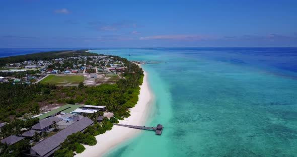 Daytime fly over clean view of a paradise sunny white sand beach and blue ocean background in colour