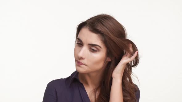 Thoughtful Attractive Young Caucasian Female in Dark Blue Shirt with Long Brown Hairstanding on