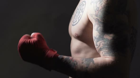 Strong Muay Thai Boxer With Tattoos Training Before Fight in the Gym