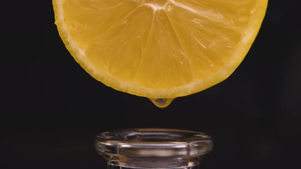 Drops of Lemon Juice Flow Down the Cut and Drip Into the Neck of a Glass Bottle