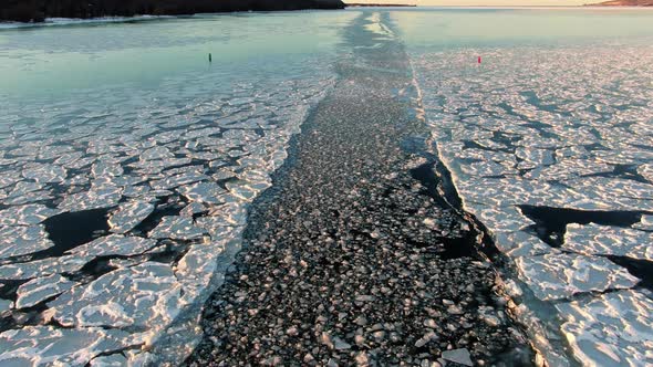 A boat's path through a frozen lake in Sturgeon Bay, Wisconsin during and afternoon wintertime day i