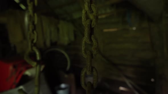 Rusty Chains Hang From the Ceiling and Dangle in an Abandoned Basement a Metal Chain and Hook Move