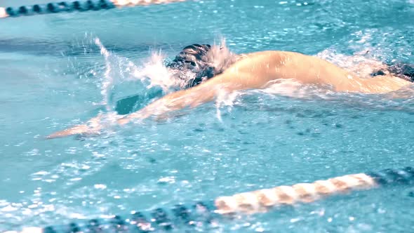 Medium Close Up Torso of Athletic Young Swimmer Performing Crawl Style in Swimming Pool