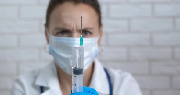 Doctor in protective uniform with vaccine.