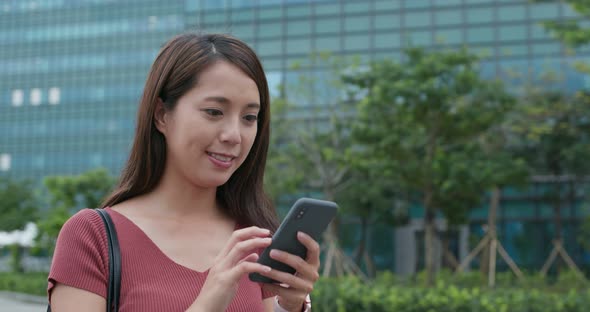 Woman look at smart phone in the street