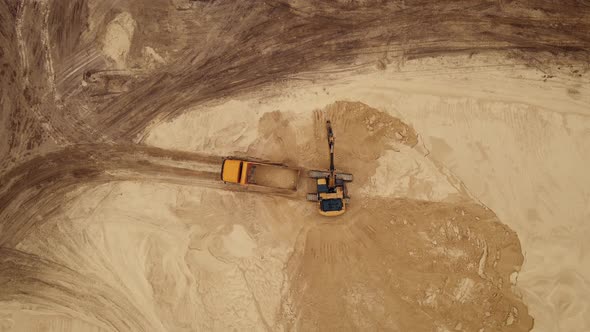 Excavator Loading Sand Into a Truck Body in Sand Quarry