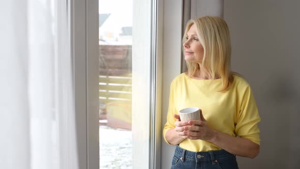 Contented Charming Mature Lady Enjoying Coffee and Daydreaming