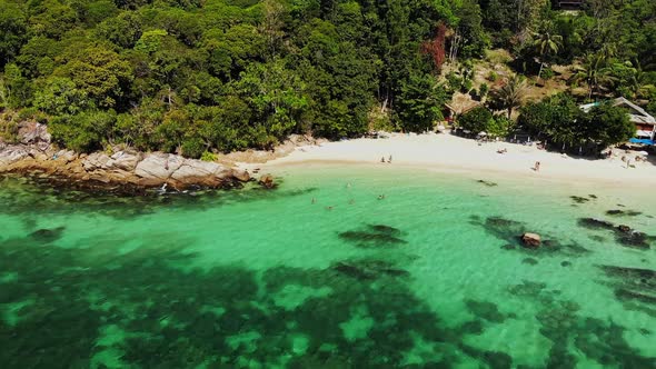 Drone Dolly Footage of a Turquoise Sea and Rocky Beach