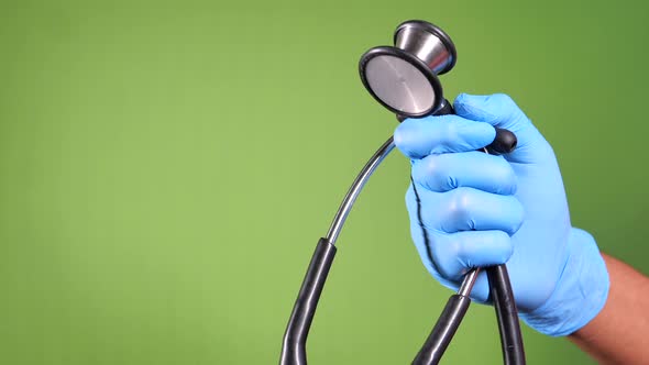 Doctor Hand in Protective Gloves Holding Stethoscope