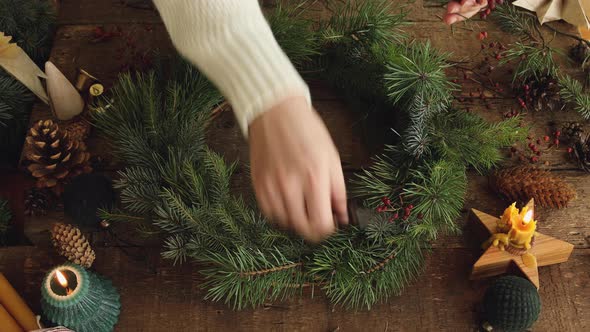 Candle burning in christmas wreath on rustic table