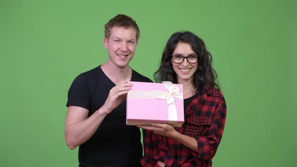 Young Couple Holding Gift Box Together