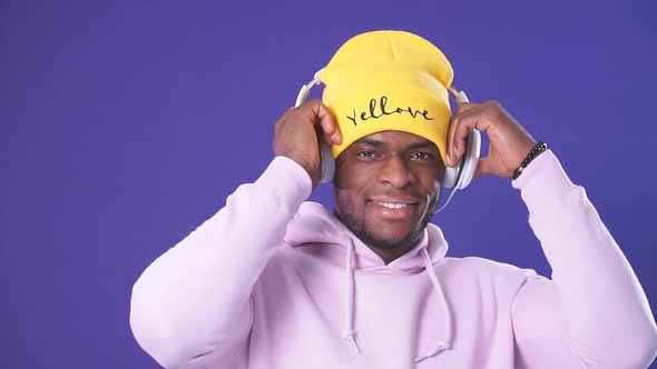 Cute African-American Man in Headphones Dressed in Street Style Wear, Listening To Music