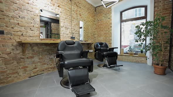 Interior of a Barber Shop with a Beautiful Design. Modern Chair with Levers in Hair Salon.