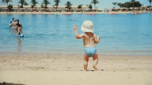 Little Boy Enjoying Warm Water at Seaside. Cute Child Running at Sand Beach.