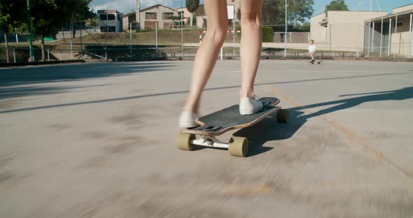Closeup Woman Legs Riding on Skate Longboard Showing to Daughter Skateboarding