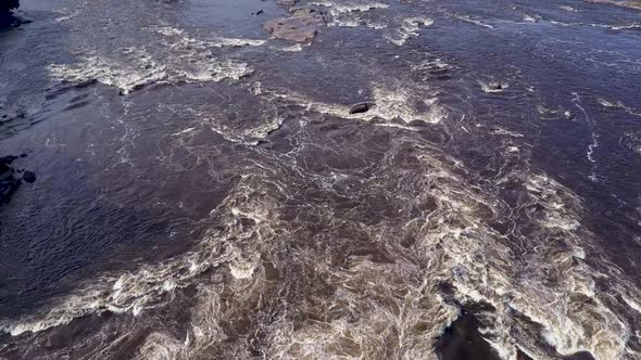 Aerial shot flying over a massive river with a vertical tilt