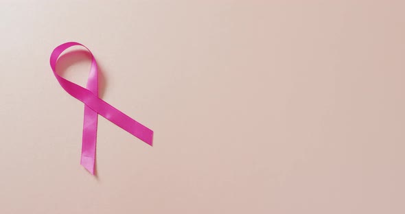 Video of pink breast cancer ribbon on pale pink background