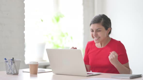 Indian Woman Celebrating Success While Using Laptop in Office