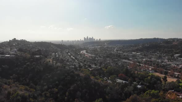 Drone flies above hillside towards Downtown Los Angeles