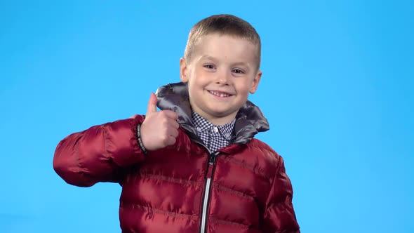 Kid Showing Thumbs Up, Laughing and Looking at the Camera.