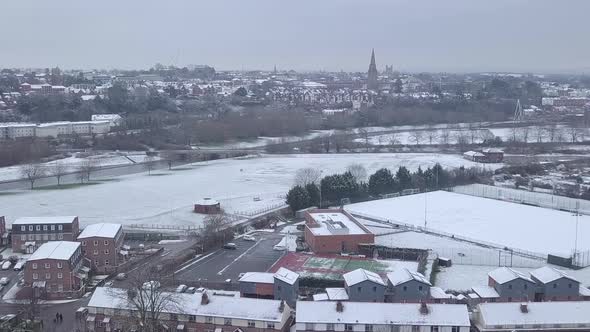 Push forward drone shot of a snowy Exeter looking towards the town centre over the River Exe