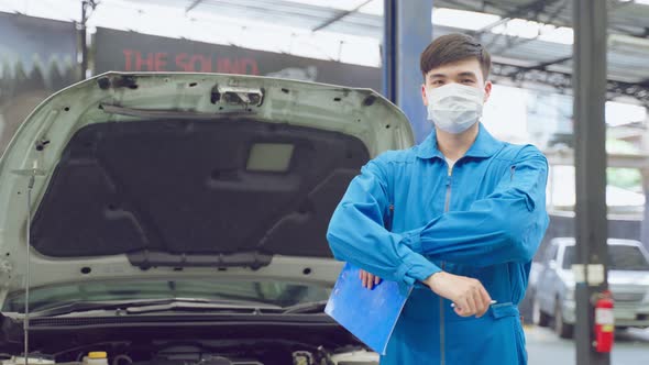 Portrait of Asian automotive mechanic men wear mask, stand in garage.