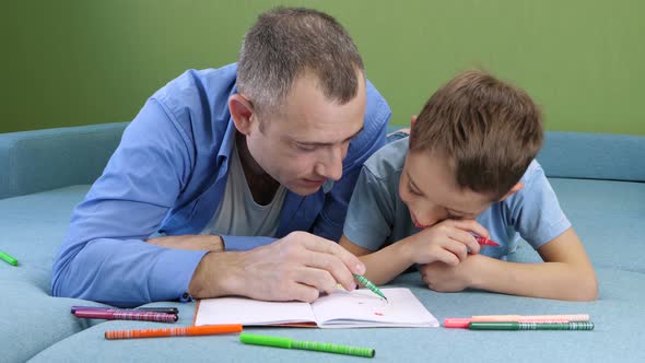 Happy Kid and Son Spend Time Drawing with Colored Pencils