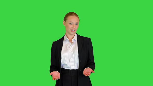 Young Businesswoman Greets and Explains Something Talking on Camera on a Green Screen Chroma Key