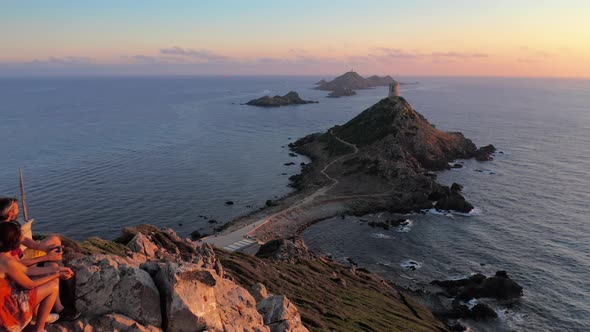 Aerial View of Two People Looking Sea Sunset on Mountain Rocky Hill