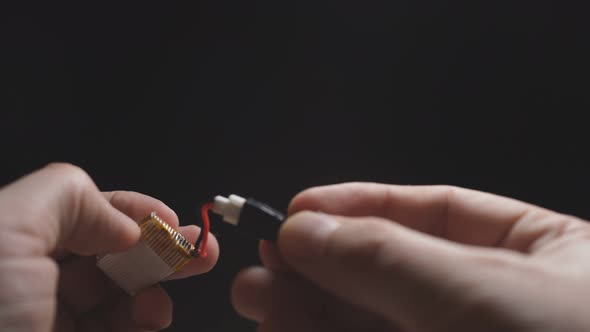 Close-up of a Man's Hand on a Dark Background Holding a Power Supply