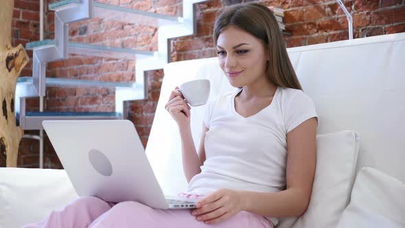 Portrait of Young Man Drinking Coffee and Working on Laptop