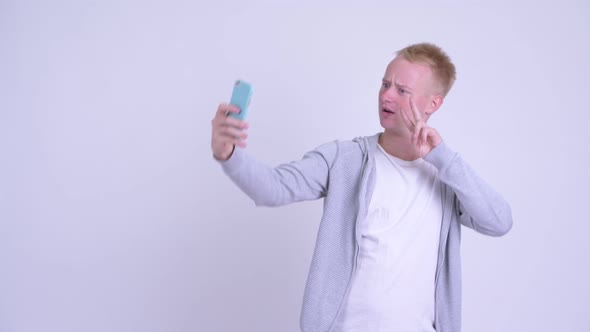 Happy Young Blonde Man Talking Selfie with Phone