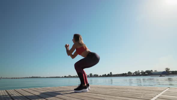 Young athletic Caucasian girl doing squats He engaged in fitness.